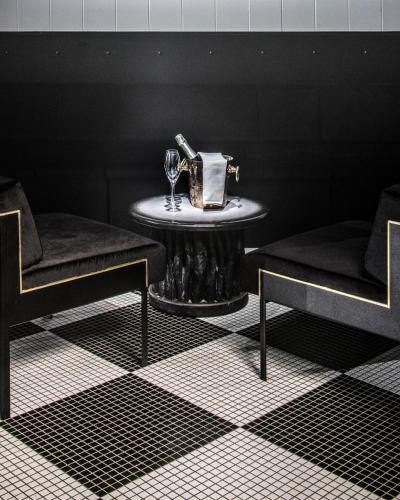 a table with two chairs and a table with wine glasses at Hotel Les Bains Paris in Paris