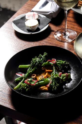 a black plate of food on a wooden table at Hotel Les Bains Paris in Paris