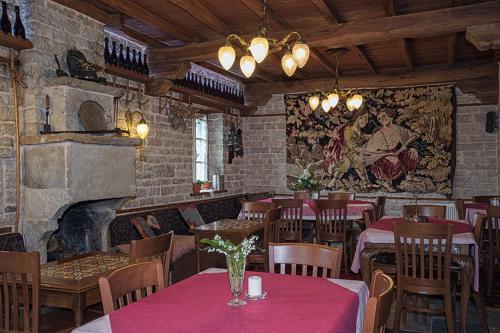 a restaurant with tables and chairs and a fireplace at Thoukididis in Kapesovo