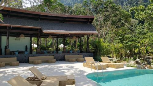 Un patio con tumbonas y una piscina. en Awei Pila (Mergui Archipelago), en Kyun Pila Island.
