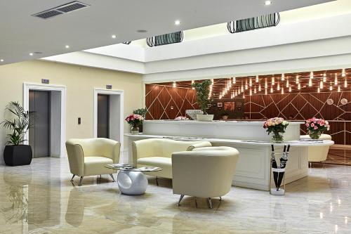 a lobby with chairs and a reception desk at Brosko Hotel Arbat in Moscow