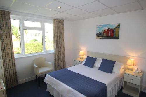 a bedroom with a bed, a desk, and a painting on the wall at Westhill Country Hotel in Saint Helier Jersey
