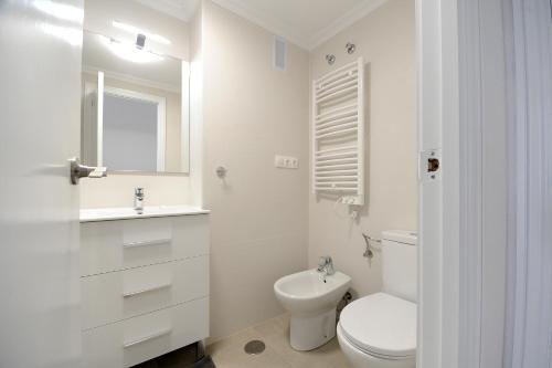 a white bathroom with a toilet and a sink at Sunset in Santa Pola
