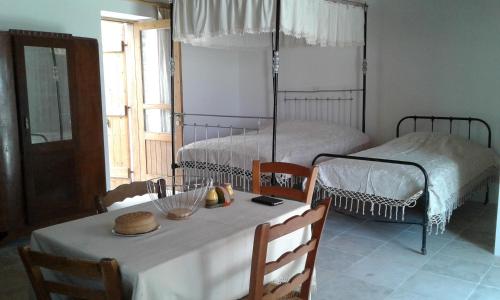 a dining room with a table and two beds at Christiana's stone studios in Pano Lefkara