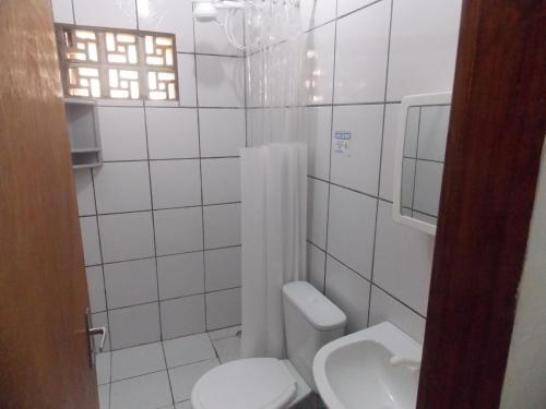 a white bathroom with a toilet and a sink at Pousada Bom Jesus in Tamandaré