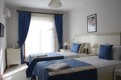 a hotel room with two beds and a window at Casa Villa By Kirte in Eceabat
