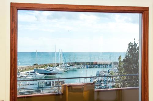 a view through a window of a beach with boats at ecoGrusApartments in El Masnou