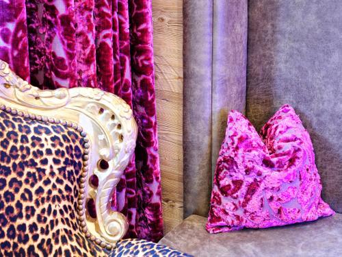 a purple couch with two pillows and a curtain at Hotel Ferienglück in Ischgl