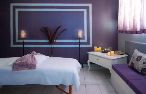 a purple bedroom with a white bed and a purple couch at Toby's Resort in Montego Bay