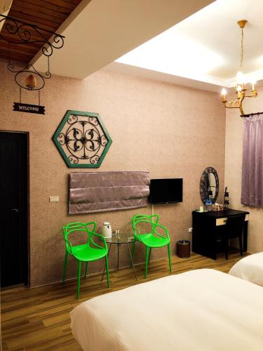 a bedroom with two green chairs and a table at 吉祥城堡 Propitious Castle B&B in Zhixue