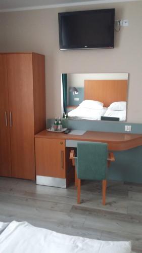 a bedroom with a bed and a desk with a mirror at Noclegi, Restauracja Eden in Witaszyce