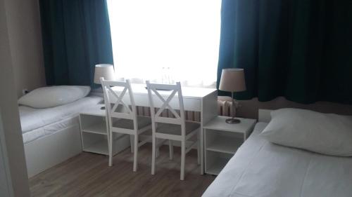 1 dormitorio con escritorio, 1 cama y ventana en Noclegi, Restauracja Eden en Witaszyce