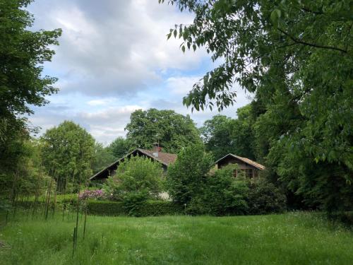 a house in the middle of a lush green field at La Datcha du Parc in Husseren-Wesserling
