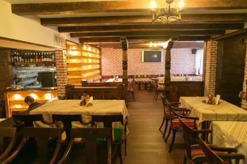 a restaurant with tables and chairs in a room at Kap House Family Hotel in Bansko
