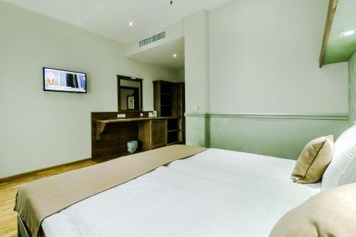 a bedroom with a bed and a tv on the wall at Hotel Marina in Pucioasa