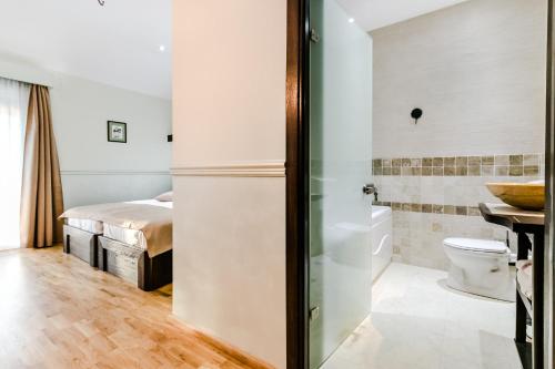 a bathroom with a bed and a toilet in a room at Hotel Marina in Pucioasa