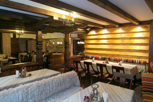 a restaurant with wooden walls and tables and chairs at Kap House Family Hotel in Bansko