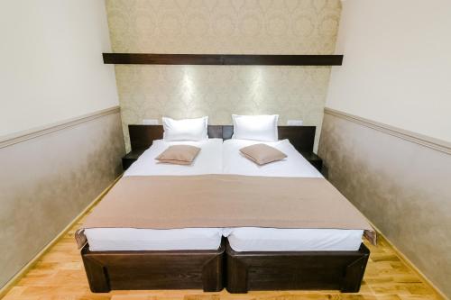 a bedroom with a large bed with two pillows at Hotel Marina in Pucioasa