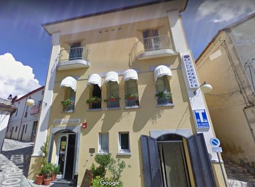 a yellow building with potted plants on the windows at Hotel San Giuliano in Accettura