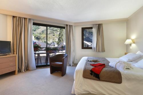 ブリッド・レ・バンにあるホテル アメリのベッドとテレビが備わるホテルルームです。
