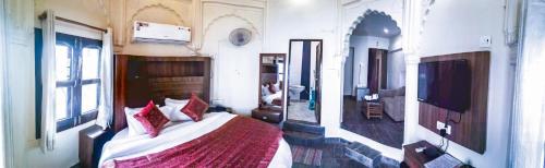 a bedroom with a bed and a television in it at Dwivedi Hotels Palace On Steps in Varanasi