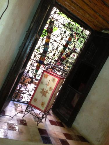 a stained glass window with a sign in front of it at Riad Mehdia in Marrakech