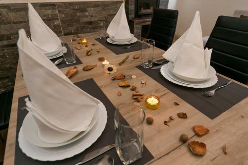 a table with white plates and napkins on it at Apartments Vukman in Trogir