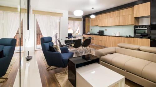 uma sala de estar com um sofá e cadeiras e uma cozinha em Dumbrava Residence em Sibiu