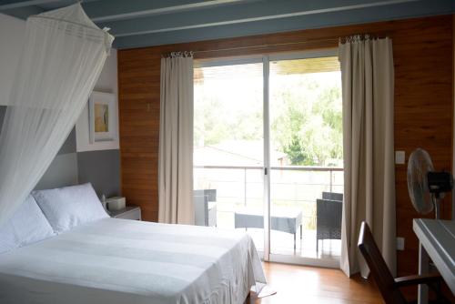 1 dormitorio con cama y ventana grande en La Pedrasanta, en La Pedrera