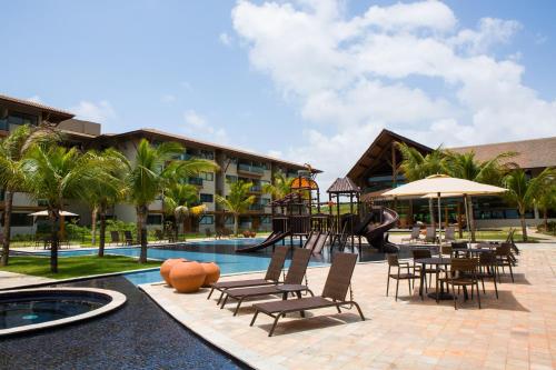 um resort com um parque infantil, uma mesa e cadeiras em Samoa Beach Resort em Porto de Galinhas