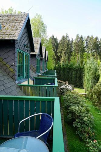 a balcony with a table and chairs on a house at Forsthaus Luchsenburg in Ohorn