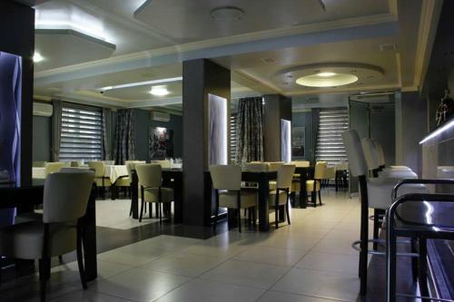 a dining room with white tables and chairs at Motel Magistrala in Doboj