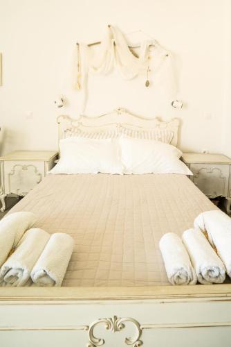 a white bed with two white towels on it at Plori Studios and Apartments in Aegiali