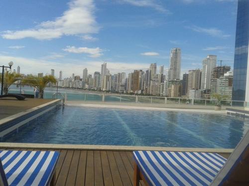a large swimming pool with a city in the background at Apto top, a melhor vista de Balneário Camboriú! in Balneário Camboriú