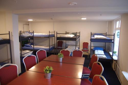 a room with a table and chairs and bunk beds at Hostel 45 in Purmerend