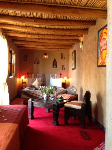 a living room with a table and a bed at Riad Mehdia in Marrakech