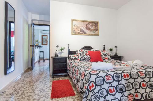セビリアにあるAcogedor apartamento centro Castellar altoのベッドルーム1室(ベッド1台、赤いラグ付)