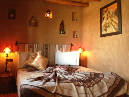 a bedroom with a bed in a room with two lamps at Riad Mehdia in Marrakech