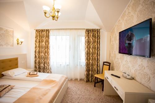 a hotel room with two beds and a television at Hotel-Restaurant Ayan Piatra Neamt in Piatra Neamţ