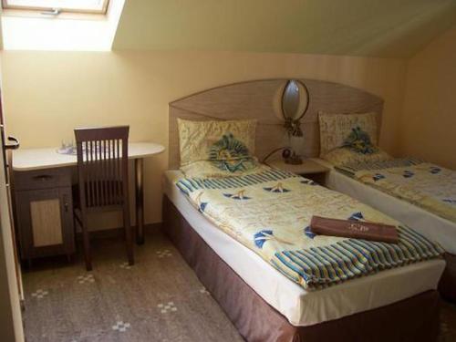 1 dormitorio con 2 camas, escritorio y espejo en Hotel Faraon, en Kielce
