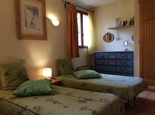 1 dormitorio con 2 camas y ventana en Les Jardins Corbès, en Corbés