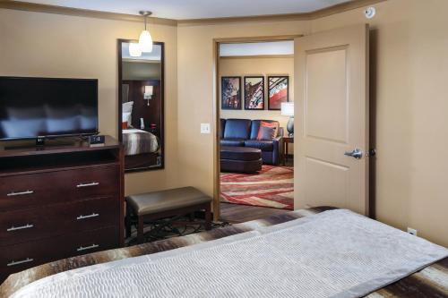 a bedroom with a bed and a tv and a mirror at ClubHouse Hotel & Suites Fargo in Fargo