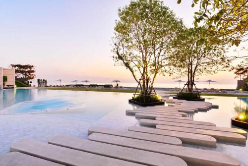 中天的住宿－Veranda Residence Pattaya x Sea & Sky View，游泳池旁的一排树木