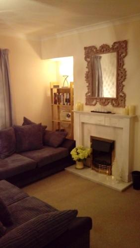 a living room with a couch and a fireplace at Heart of Filey in Filey