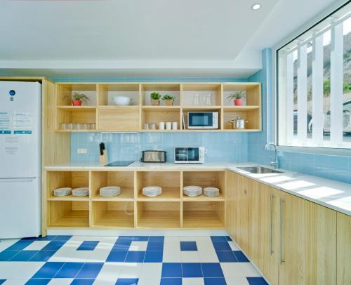 a kitchen with wooden cabinets and a blue tiled floor at LoopINN Hostel Cartagena in Cartagena