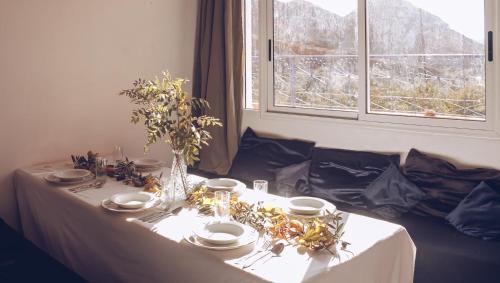 a table with a white table cloth and a window at Monkey Fingers House by Fatima mellal in Tinerhir