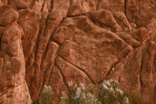 a large rock wall with patterns on it at Monkey Fingers House by Fatima mellal in Tinerhir