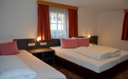 カップルにあるHaus Tschidererのベッド2台と窓が備わるホテルルームです。
