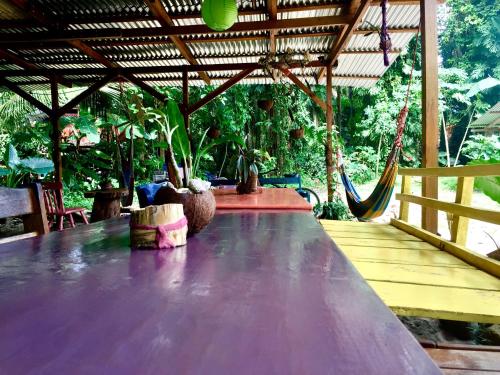 a large wooden table with a hammock on a porch at Oasis in Puerto Viejo