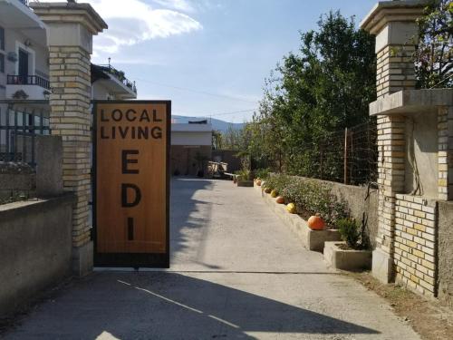 a sign for a local living sign on a street at bed & breakfast Local Living Edi in Berat